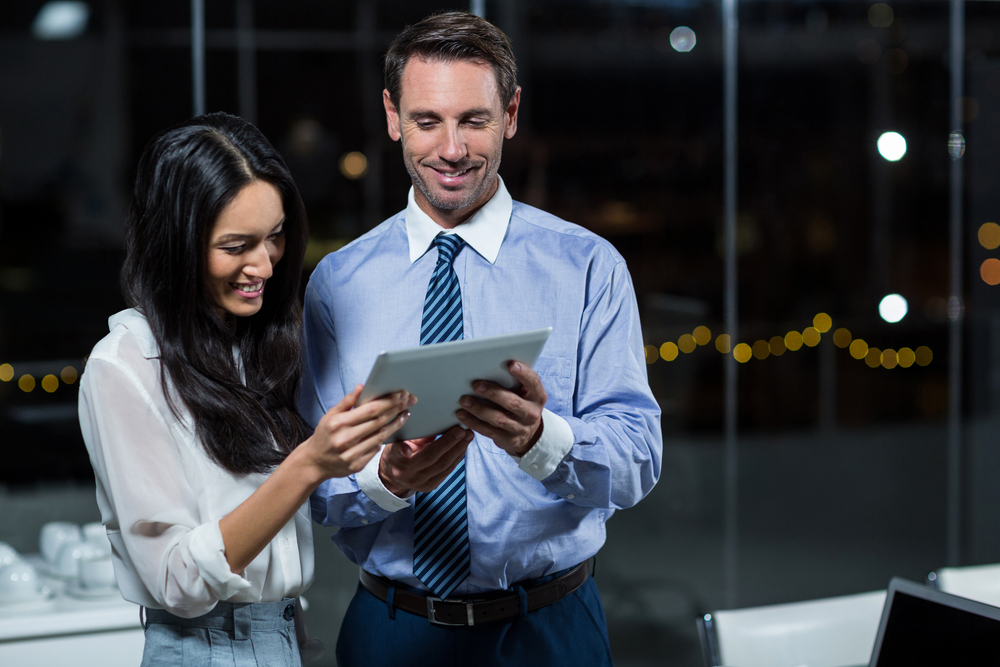 Businessman discussing with colleague over digital tablet in the office